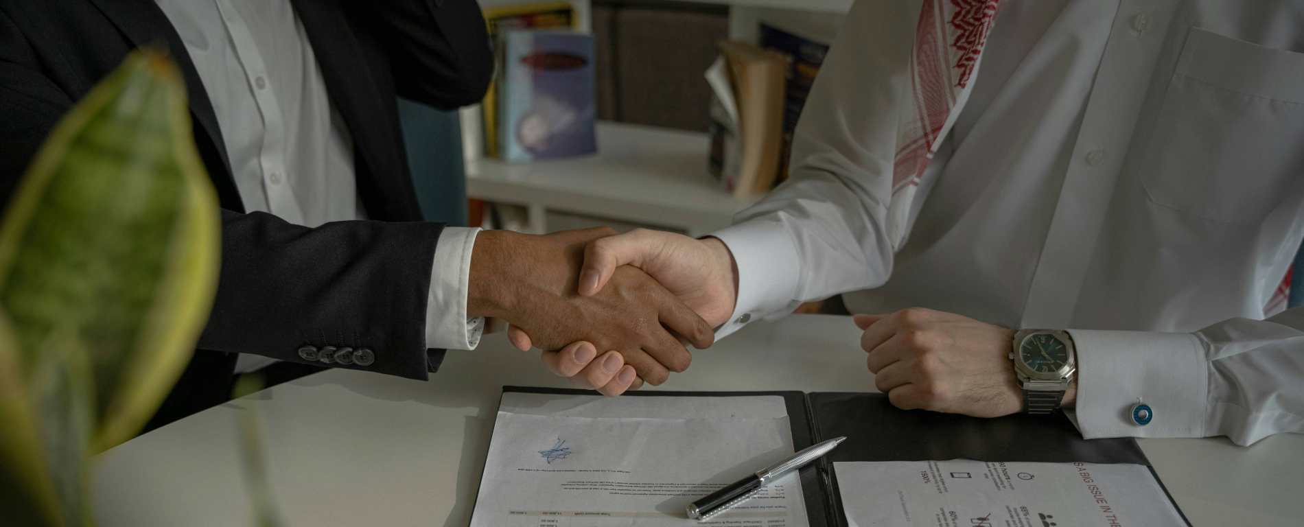Two men shaking hands over a document