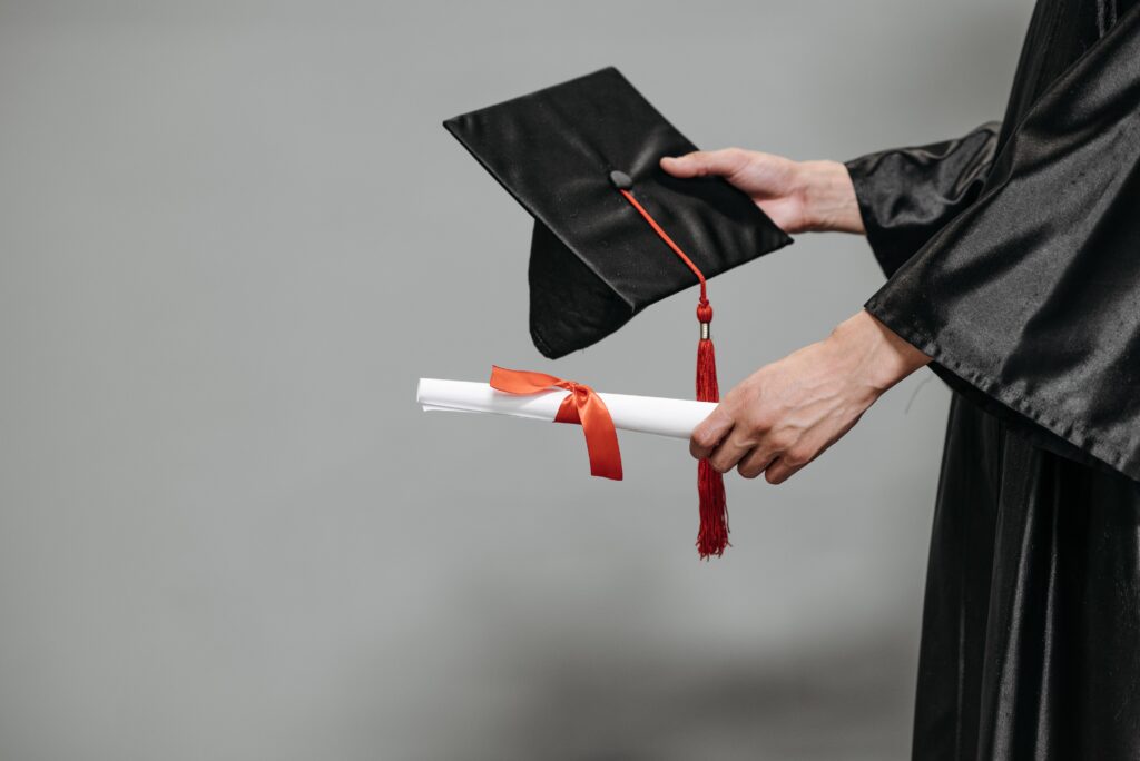 A graduate holding accountant degree certificate and mortarboard hat